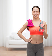 Image showing sporty woman with towel and water bottle