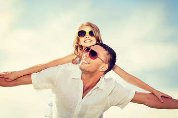 Image showing happy father and child in sunglasses over blue sky