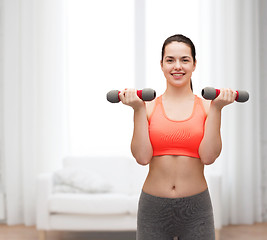 Image showing young sporty woman with light dumbbells