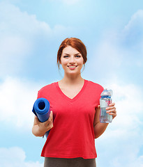 Image showing smiling girl with bottle of water after exercising