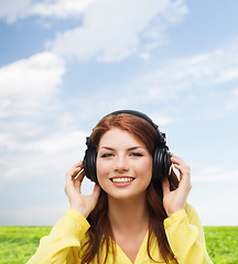 Image showing smiling young girl in headphones at home