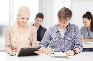 Image showing two smiling students with tablet pc and notebooks