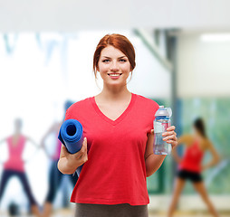 Image showing smiling girl with bottle of water after exercising