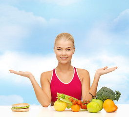 Image showing smiling woman with fruits and hamburger