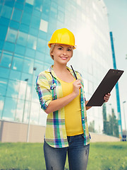 Image showing smiling woman in helmet with clipboard