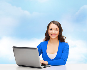 Image showing smiling woman in blue clothes with laptop computer