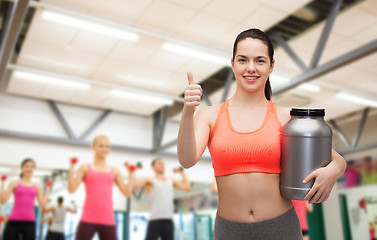 Image showing teenage girl with jar of protein showing thumbs up