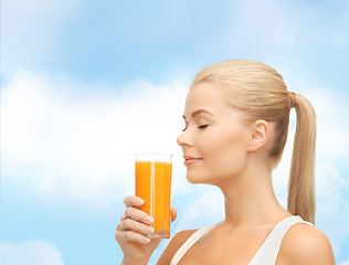 Image showing young woman drinking orange juice