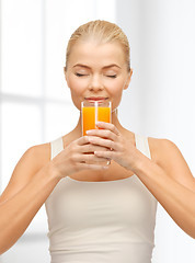 Image showing young woman drinking orange juice