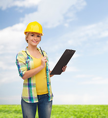 Image showing smiling woman in helmet with clipboard