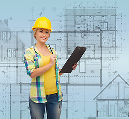 Image showing smiling woman in helmet with clipboard