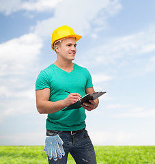 Image showing smiling man in helmet with clipboard