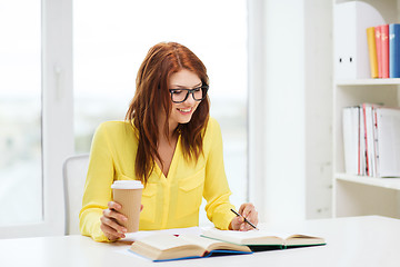 Image showing smiling student girl reading books in library