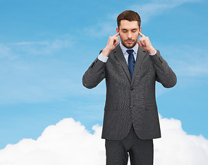 Image showing annoyed businessman covering ears with his hands