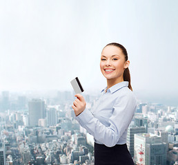 Image showing smiling businesswoman showing credit card