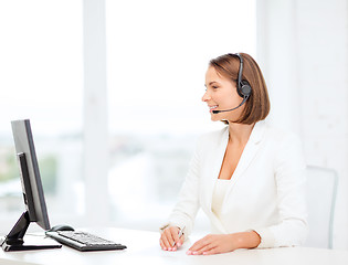 Image showing friendly female helpline operator with computer