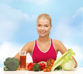 Image showing smiling young woman with organic food on the table