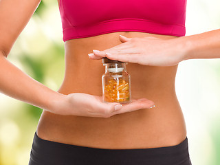 Image showing close up of female hands with bottle of capsules