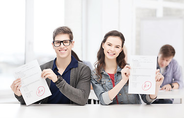 Image showing two teenagers holding test or exam with grade A