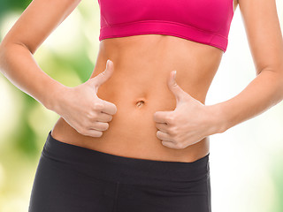 Image showing close up of female abs and hands showing thumbs up