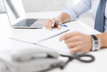 Image showing businessman writing in notebook