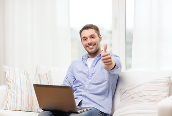 Image showing smiling man working with laptop at home