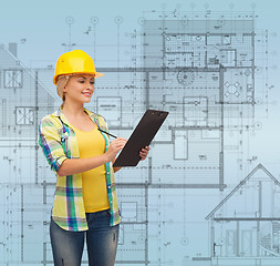 Image showing smiling woman in helmet with clipboard