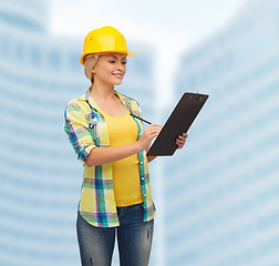 Image showing smiling woman in helmet with clipboard