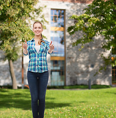 Image showing young woman in casual clothes showing thumbs up