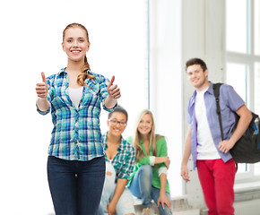 Image showing young woman in casual clothes showing thumbs up