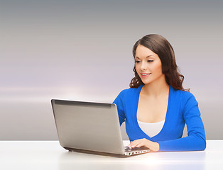 Image showing smiling woman in blue clothes with laptop computer