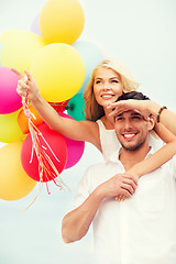 Image showing couple with colorful balloons at seaside