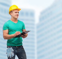 Image showing smiling man in helmet with clipboard