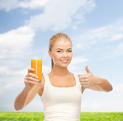 Image showing smiling woman holding glass of orange juice