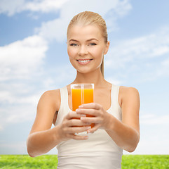 Image showing smiling woman holding glass of orange juice