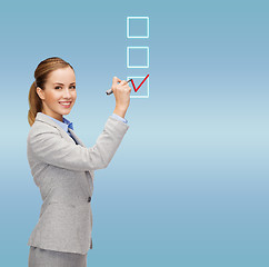 Image showing businesswoman writing something in air with marker