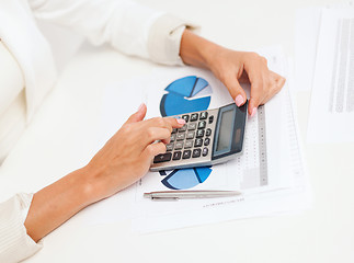 Image showing businesswoman working with calculator in office