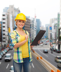 Image showing smiling woman in helmet with clipboard