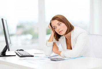 Image showing tired businesswoman with computer and papers