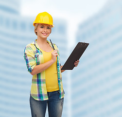 Image showing smiling woman in helmet with clipboard