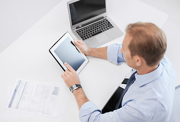 Image showing businessman with tablet pc and papers in office