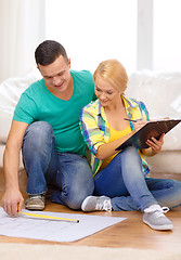 Image showing smiling couple looking at bluepring in new home