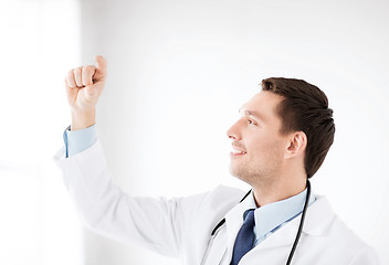 Image showing young doctor holding something imaginary