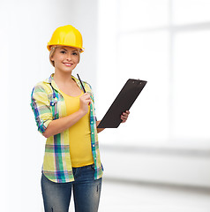 Image showing smiling woman in helmet with clipboard