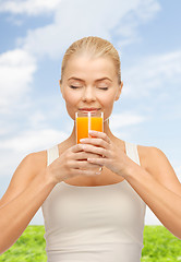 Image showing young woman drinking orange juice