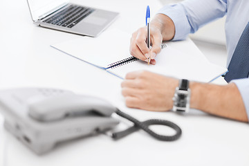 Image showing businessman writing in notebook