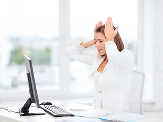 Image showing stressed businesswoman with computer at work