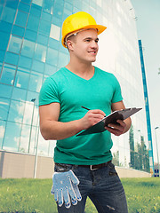 Image showing smiling man in helmet with clipboard