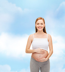 Image showing happy future mother touching her belly