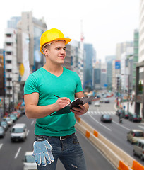 Image showing smiling man in helmet with clipboard